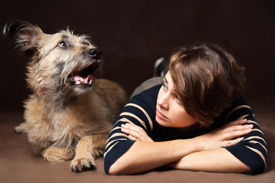 Portrait of a beautiful young woman with a funny shaggy dog on a