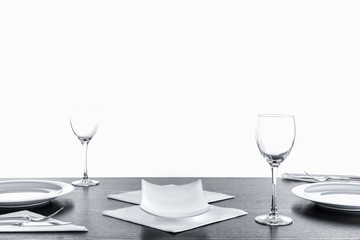 Gedeckter Holztisch mit Besteck, Servietten, Teller, Weinglas und Schale, leer
