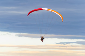 Paraglider flying in the sea of dark clouds