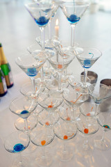 Beautiful wedding slide champagne for bride and groom indoors. Colorful glasses for alcohol with berries. Beauty of bridal interior for marriage. Bright bar for celebration