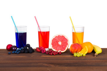 Fresh juice and fruit on a wooden table isolated on white background