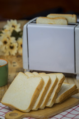 Toaster with slide bread on wood table with hot coffee - Selective focus