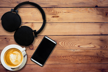 Headphone coffee and phone on wood background and texture with s