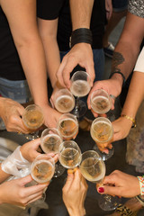 People holding glasses of champagne making a toast - flat lay