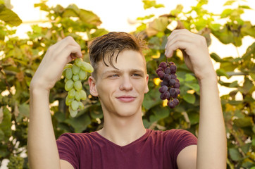 Teen holding two grapes white and red 