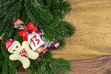 ein Plätzchenmann und eine Weihnachtssäckchen liegen auf Tannenzweigen