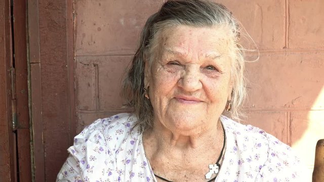 Close-up portrait old woman without teeth with poor eyesight