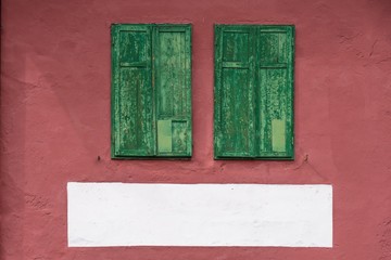 Grüne Holzfensterläden an roter Fassade