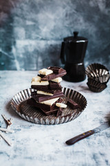 Stack of chocolate sliced. White, dark, milk chocolate on a cooking sheet over stone table. 