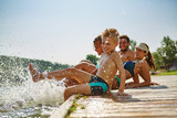 Familie hat Spaß und plantscht am Wasser