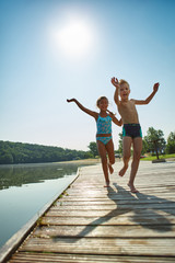 Kinder spielen auf einem Steg am See