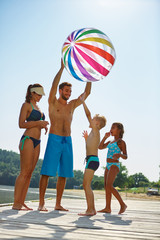 Familie mit Wasserball am See
