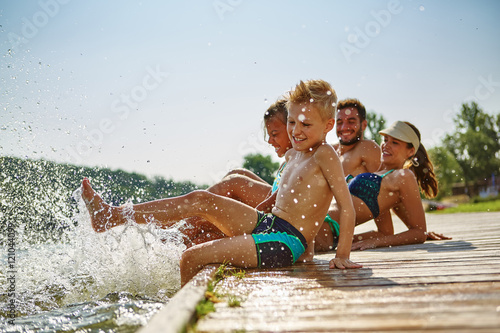 Familie hat Spaß und plantscht am Wasser