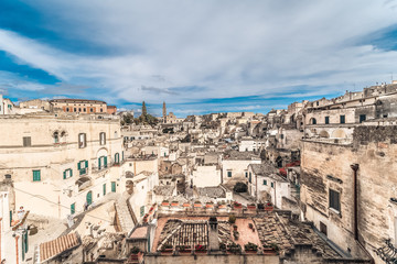 Naklejka premium panoramic view of typical stones (Sassi di Matera) and church of Matera under blue sky