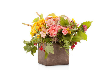 Autumn flower bouquet with berries and apple in wooden box