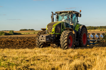 Agriculture plowing tractor on wheat cereal fields