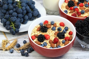 Oatmeal  breakfast, wild strawberries, blueberries, blackberries, grapes, almonds