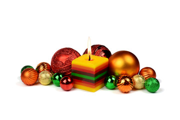 Christmas composition with burning candle and colored balls.