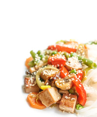 Asian noodles with tofu cheese, vegetables, sauce on a white background.