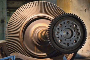Detailed Picture of the rotor of steam turbine for coal electric power plant or power station on the support. Picture of the main shaft, propelers and gear Wheel.