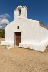 Fototapeta na wymiar Church of Saint Lucia, Posada. / North Sardinia. Small church with a single nave, the white facade with the entry portal which is surmounted by a large belfry.