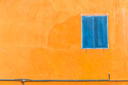 Abstract closed blue window on orange wall