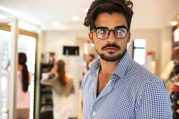 Obraz premium Handsome male wearing eyeglasses in optician store.
