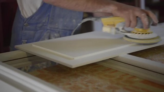 Closeup of carpenter using sander