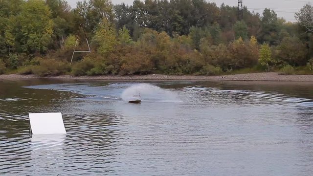 man on a wakeboard falls after the jump. loser. bad jump on wakeboard. wakepark