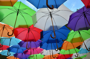 Colorful umbrellas with a part of blue sky with clouds