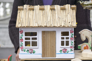 Toy cottage with a thatched roof and large windows.
