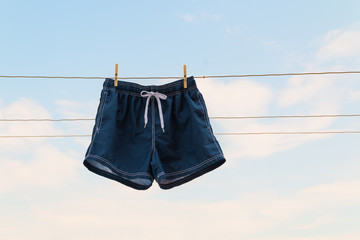 Shorts hanging on the clothesline against sky background