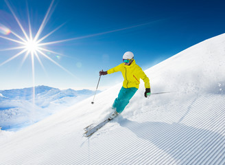 Skier skiing downhill in high mountains