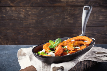 Roasted, baked pumpkin with addition aromatic herbs, goat cheese and mint. Healthy food concept with copy space.