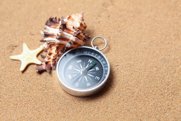 Compass, seashell on and starfish the sea sand