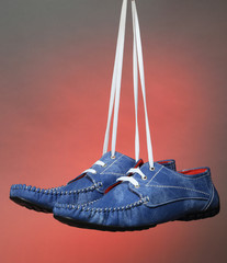 Blue man casual shoes on red lighting background.