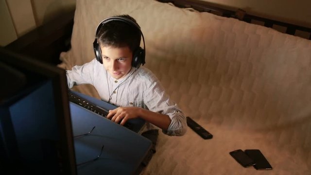 Teen boy plays games on the computer at night. Online Games