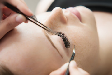 Eyelash Extension Procedure.  Woman Eye with Long Eyelashes.