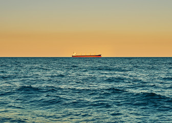Sea view. Panorama of sea and sky. Sea idyll. Lonely cargo ship in the distance