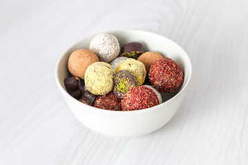 Colorful dessert, raw vegan sweets and organic chocolate in a bowl