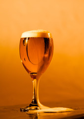 Glass of beer frothing over