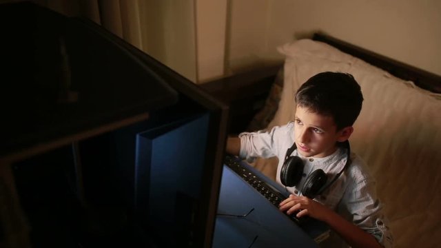 Teen boy plays games on the computer at night. Online Games