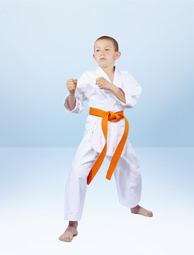 Boy karateka stands in the rack karate