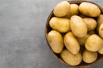 New potato on the bowl, gray background.