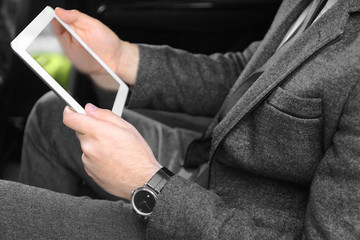 Businessman with tablet in a car