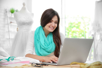 Pretty young dress designer at workplace