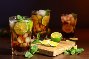 Kitchen board with cuba libre cocktails, lime and mint on wooden table