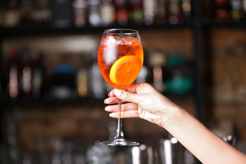 Woman hand holding tasty long drink in bar