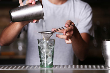 Barman preparing cocktail on bar counter