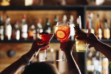 Vrienden roosteren met cocktails in bar